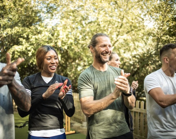 A group of people applauding as they look at something off camera.